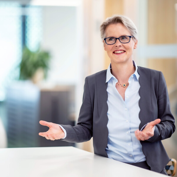 Birgit Frohnhoff, Vorständin steht an einem Tisch in einer Gesprächssituation.