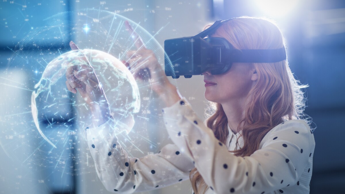 Eine junge Frau mit VR-Brille umkreist mit ihren ausgestreckten Zeigefingern eine weiße 3D-Visualisierung der Erde, die sich vor ihr abgebildet ist..