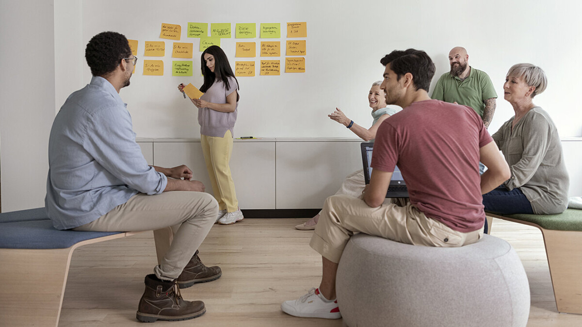 Eine Gruppe Menschen sitzen und nehmen an einem Workshop teil.